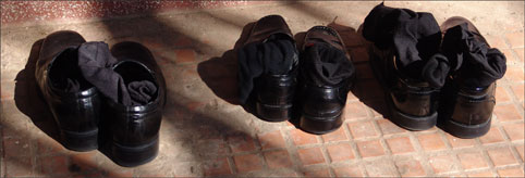 Schuhe vor der Türe des Abtes von Wat Botum